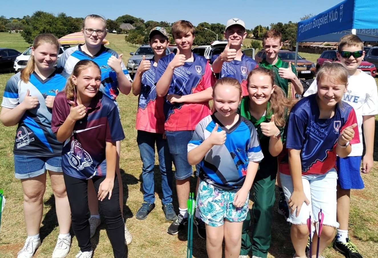 Young archers smiling together at a Centurion Boogskiet club day.